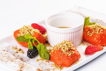Turkish dessert recipe. Pumpkin baked in honey with nuts, served with scaram sauce and berries - strawberries, blueberries