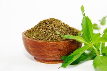 dried mint powder and natural green leaves of this plant in wooden plate