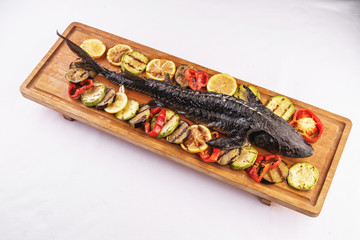  Seafood, Mediterranean cuisine. Baked sturgeon fish with grilled vegetables, tomatoes, lemon,...