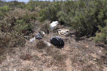 Pile of garbage on green grass in the nature environment problems.