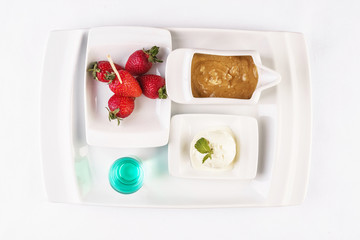 vanilla ice cream fondue, milk chocolate, and strawberries on skewers