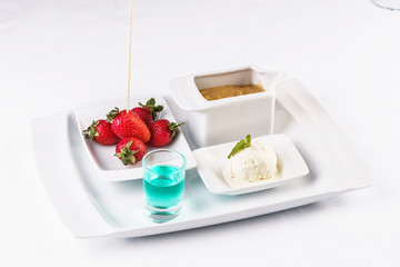 vanilla ice cream fondue, milk chocolate, and strawberries on skewers