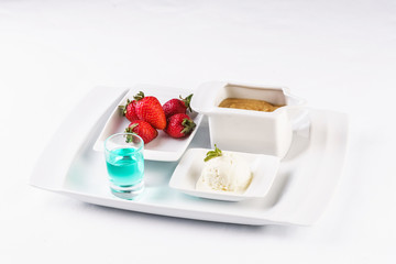 vanilla ice cream fondue, milk chocolate, and strawberries on skewers