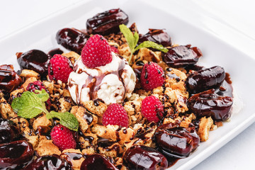 Berry-chocolate cake with ice cream, chocolate sauce and dates