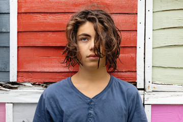 Portrait of a young man with colored fence behind