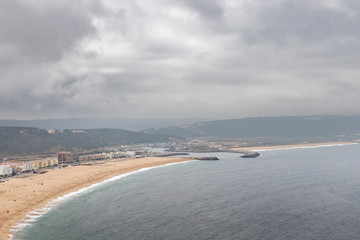 Nazare, Portugal - July 19, 2019 - The bay of Nazre shrouded in the mist, as seen from the Miradouro