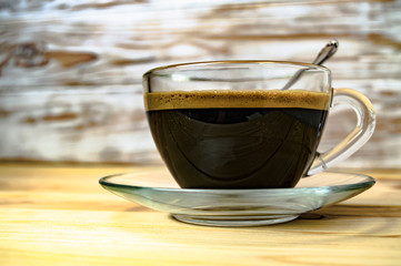 glass cup with espresso on a wooden table closeup