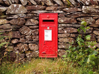 Roter Briefkasten in Steinmauer