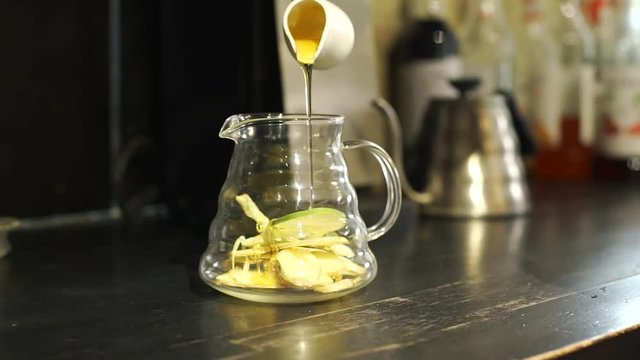 Bartender Pouring Honey in the Glass Jar in Coffee Shop. The Process of Making Healthy Tea with Giger, Lemongrass and Lime. Healthy Food and Drinks for Good Living Lifestyle Concept
