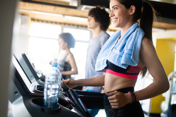 Fototapeta na wymiar Fit people running in machine treadmill at fitness gym