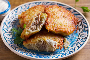 Potato Pancakes Filled With Meat. Vegetable fritters stuffed with meat. Latkes on blue plate