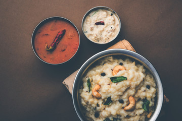 Ven pongal recipe is a popular South Indian food prepared with rice & moong dal and served with sambar and coconut chutney, selective focus