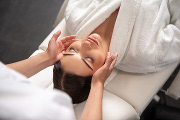 Fototapeta na wymiar Charming young woman receiving therapeutic massage at spa salon