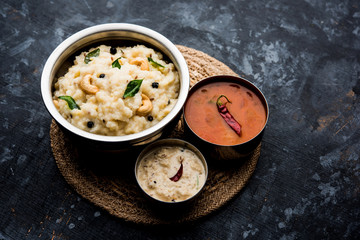 Ven pongal recipe is a popular South Indian food prepared with rice & moong dal and served with sambar and coconut chutney, selective focus