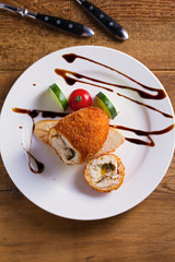Chicken Kiev and vegetables. Breaded chicken breast stuffed with herbs and butter. View from above, top studio shot