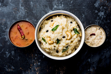 Ven pongal recipe is a popular South Indian food prepared with rice & moong dal and served with sambar and coconut chutney, selective focus