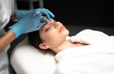 Young woman getting beauty injections at spa salon