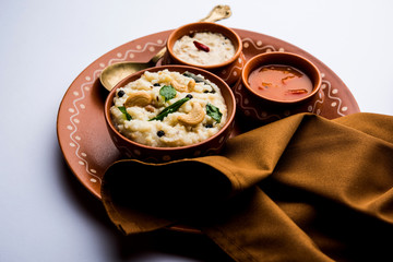 Ven pongal recipe is a popular South Indian food prepared with rice & moong dal and served with sambar and coconut chutney, selective focus