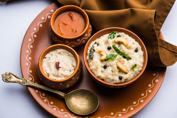 Ven pongal recipe is a popular South Indian food prepared with rice & moong dal and served with sambar and coconut chutney, selective focus
