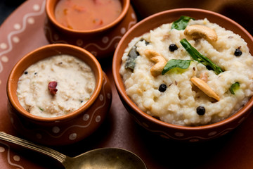Ven pongal recipe is a popular South Indian food prepared with rice & moong dal and served with sambar and coconut chutney, selective focus