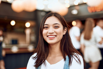 Pretty smiling asian lady on city view