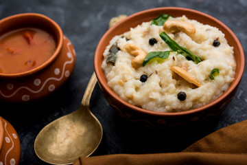 Ven pongal recipe is a popular South Indian food prepared with rice & moong dal and served with sambar and coconut chutney, selective focus