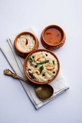 Ven pongal recipe is a popular South Indian food prepared with rice & moong dal and served with sambar and coconut chutney, selective focus