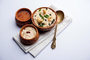 Ven pongal recipe is a popular South Indian food prepared with rice & moong dal and served with sambar and coconut chutney, selective focus