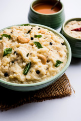 Ven pongal recipe is a popular South Indian food prepared with rice & moong dal and served with sambar and coconut chutney, selective focus