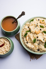 Ven pongal recipe is a popular South Indian food prepared with rice & moong dal and served with sambar and coconut chutney, selective focus