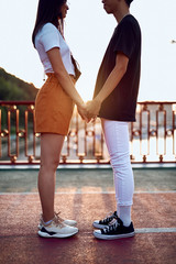 Fototapeta premium Young happy lovers staying together holding hands