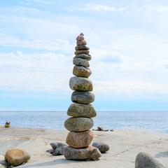 Fototapeta na wymiar Stacked Rocks balancing, stacking with precision. Stone tower on the shore. Copy space.