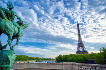 Fototapeta premium The Eiffel Tower across the Seine River in Paris, France on a sunny day with beautiful clouds.