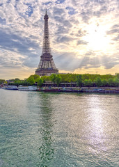 Fototapeta premium The Eiffel Tower across the Seine River in Paris, France on a sunny day with beautiful clouds.