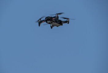 drone moving the blades flying through the blue sky