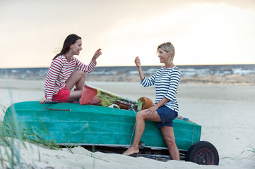 Obraz premium Two young women having conversation at summer windy seacoast