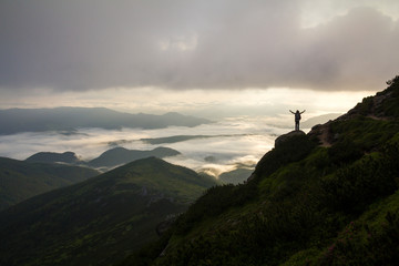 Wide mountain panorama. Small silhouette of tourist with backpack on rocky mountain slope with...