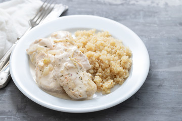 dish of meat with sauce and boiled quinoa on white wooden background