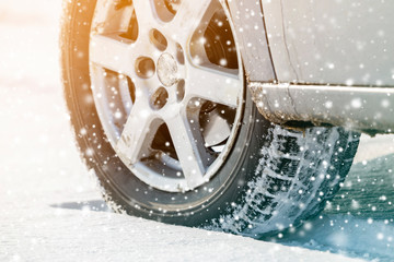 Close-up of car wheels rubber tires in deep winter snow. Transportation and safety concept.