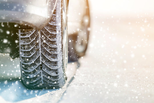 Close-up of car wheels rubber tires in deep winter snow. Transportation and safety concept.