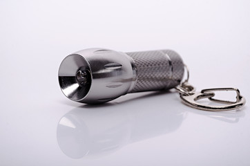 metal pocket flashlight keychain with chain isolated on white background