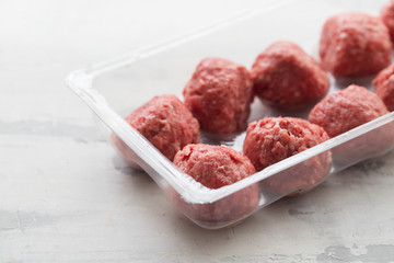 raw meatballs with pepper and salt in plastic box
