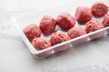 raw meatballs with pepper and salt in plastic box