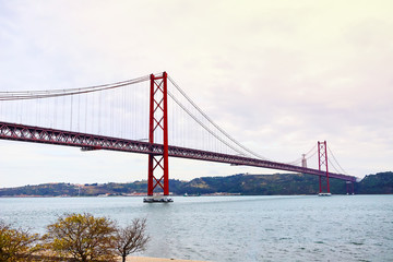 Fototapeta na wymiar The 25 April bridge (Ponte 25 de Abril) is a steel suspension bridge located in Lisbon, Portugal, crossing the Targus river. It is one of the most famous landmarks of the region.