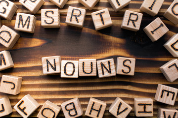 nouns composed of wooden cubes with letters, Part of speech concept scattered around the cubes...
