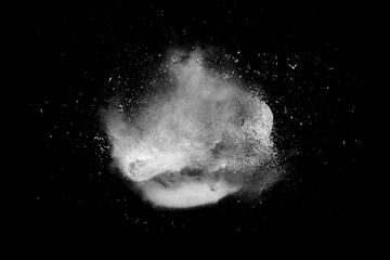 Freeze motion of white powder paint exploding isolated on black, dark background. Abstract design...