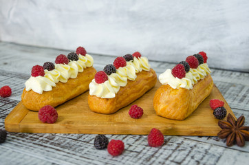 eclairs with vanilla cream cheese decorated with fresh berries
