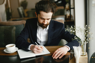 Handsome man in a black suit. Businessman working in a office