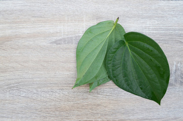 Betel leaf on a wooden plate with on wood background.