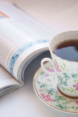 Coffee mug with newspaper on teal rustic table, cozy breakfast, vintage style